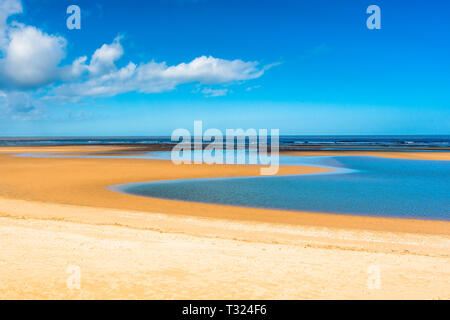 Tide pool of water at low tide on Barnham Overy Staithe beach on Holkham bay, North Norfolk coast, East Anglia, England, UK. Stock Photo