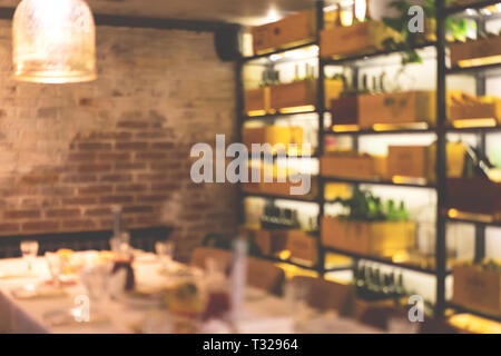 Blurred cafe background with served festive table and beautiful lighting of wine racks. Stock Photo