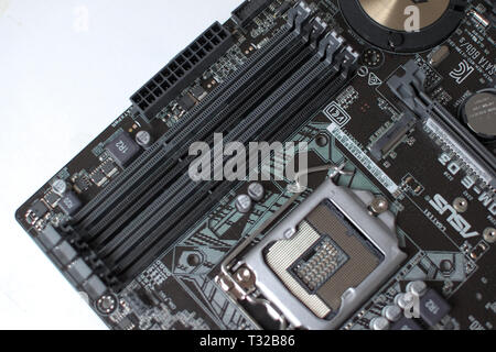 Modern computer ATX format motherboard. Electronic components, sockets and soldering points can be clearly seen. Stock Photo
