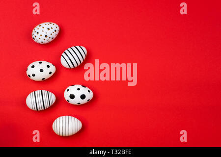 Different graphic hand-painted eggs on trendy coral background. Easter concept. Place for text. Stock Photo