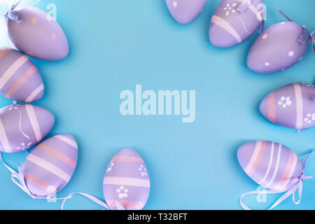 Frame of beautiful decorative eggs on blue pastel background. Easter concept. Place for text. Stock Photo