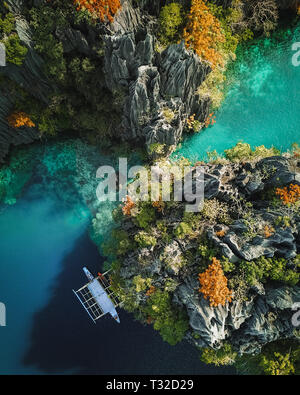 A top down aerial view of the Twin Lagoon in Coron, Philippines, with a boat anchored along the limestone cliffs Stock Photo