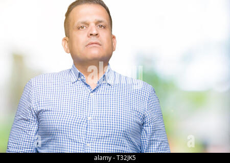 Middle age arab business man over isolated background Relaxed with serious expression on face. Simple and natural looking at the camera. Stock Photo