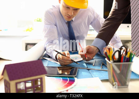 Two male workers examining blueprint papers Stock Photo