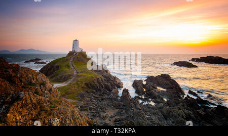 Dramatic sunset, Twr Mawr lighthouse Llanddwyn Island, Anglesey looking out to southern entrance of the Menai Strait. Classic UK landscape photograph.