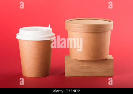 Disposable coffee cup and container for soup on a red background. Stock Photo