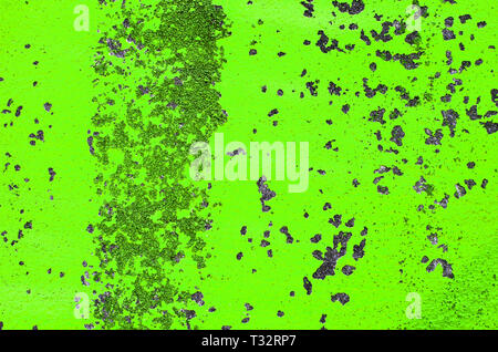 Old wall with peeling bright toxic green paint. Texture of bright green peeling paint background on concrete wall Stock Photo