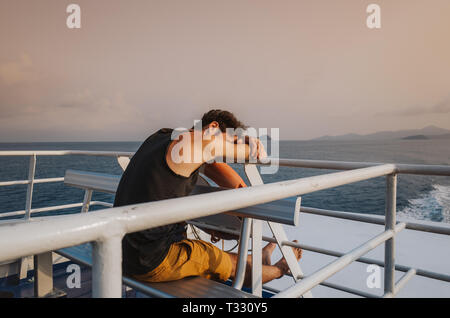 young man sleeping on a cruise ship near Koh Tao Island, Thailand Stock Photo