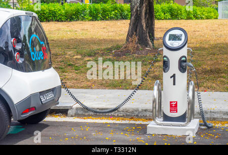 Blue SG Bolloré Bluecar, electric car charging at an electric vehicle recharching station in Singapore. Stock Photo