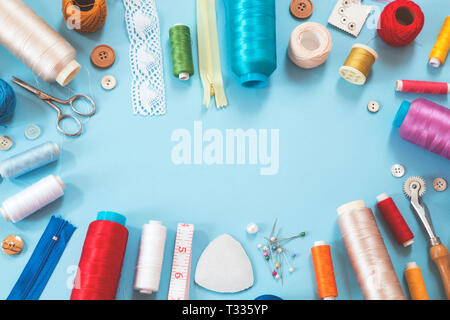 Various sewing items on blue background Stock Photo