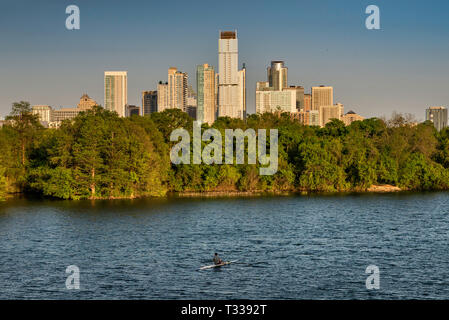 Kayaker at Lady Bird Lake on Colorado River, downtown towers in distance, view from pedestrian bridge beneath MoPac Expressway in Austin, Texas, USA Stock Photo