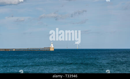 Blyth Lighthouse, the pier and a wind turbine on the North Sea Coast, seen on South Beach in Blyth, England, UK Stock Photo