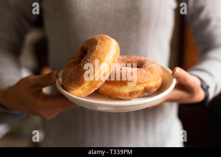 take a donut by woman's hand in house Stock Photo