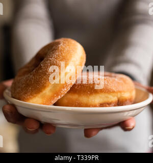 take a donut by woman's hand in house Stock Photo