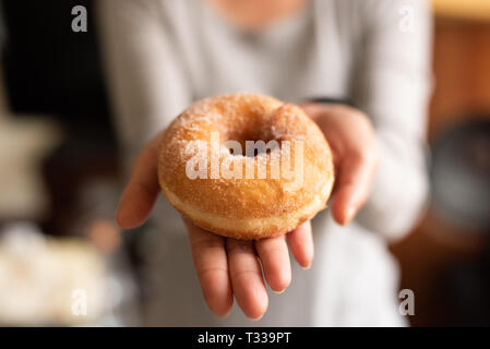 take a donut by woman's hand in house Stock Photo