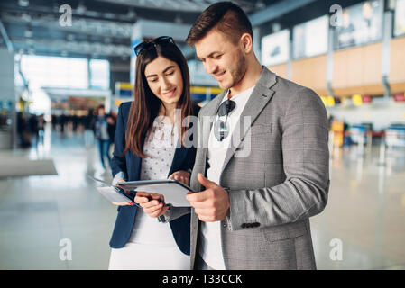 Two passengers of business class in airport, working trip. Businessman and businesswoman in air terminal, negotiation travel Stock Photo