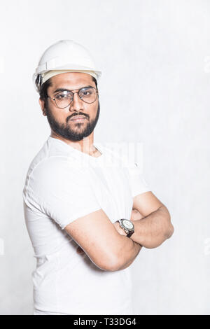 Young builder engineer with glasses and a white protective helmet Stock Photo