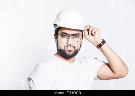 Young builder engineer with glasses and a white protective helmet Stock Photo