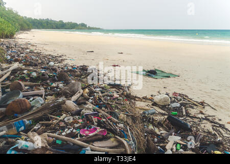 Beach pollution. Plastic bottles and other trash on sea beach. garbage nailed by a wave from the sea on a beach Stock Photo