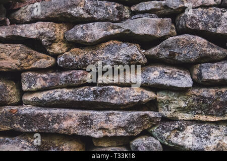 old stone wall. the texture of the stone covered with moss Stock Photo