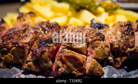Close-up detail of a beef rib grilled with fried potatoes, Spanish food Stock Photo