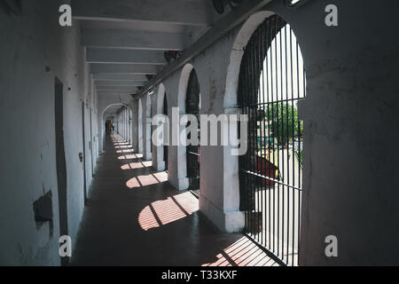 abandoned corridor in old prison. Long Corridor in Cellular Jail, Port Blair, Andaman Islands, India. Solitary confinement cells along the white wall  Stock Photo
