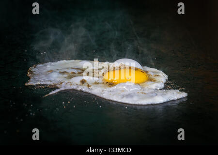 Fried eggs fried eggs in a pan. Hot appetizing dish that is eaten unmarried men and poor students. one fried egg Stock Photo