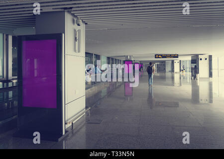 Blank mock up of vertical street poster billboard on Airport Background with plane passengers. inside an unknown airport. the interior of the airport Stock Photo