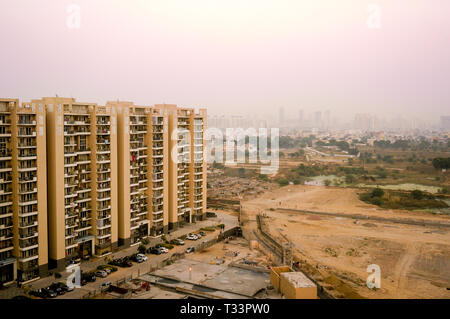 Skyscrapers in gurgaon looking out over barren land and a village Stock Photo