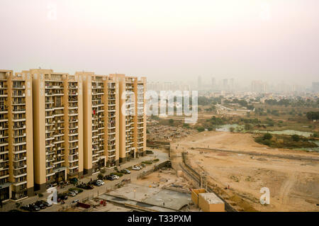 Skyscrapers in gurgaon looking out over barren land and a village Stock Photo
