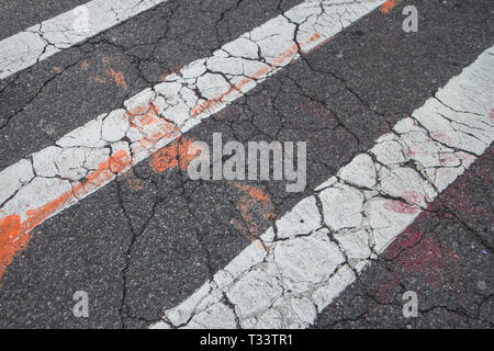 cracking tarmac and crosswalk white lines Stock Photo