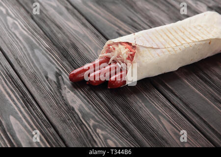 hunting sausages in pita bread on a dark wooden background Stock Photo