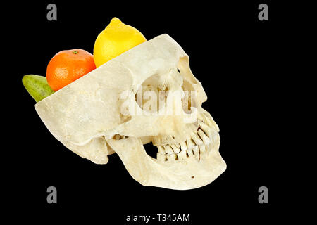 Human skull filled with fruits isolated on black background Stock Photo