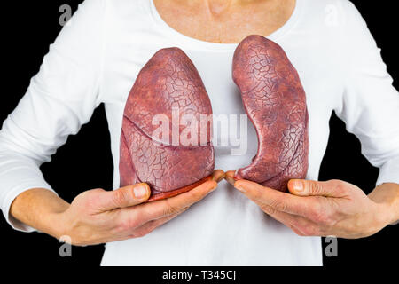 Woman holds models of two lungs at white body isolated on black background Stock Photo