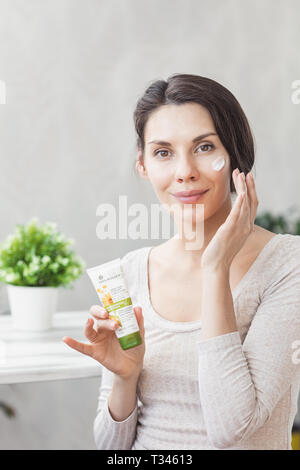 Portrait Of Beautiful Young Woman With Natural Makeup Applying white Under Eye Patches Beauty Mask On Face. Eye Skin Treatment. Portrait woman with ey Stock Photo