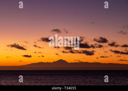 Mount Tiede on Tenerife in silhouette at  dusk from Puerto de Las Nieves on Gran Canaria in the Canary Islands Stock Photo