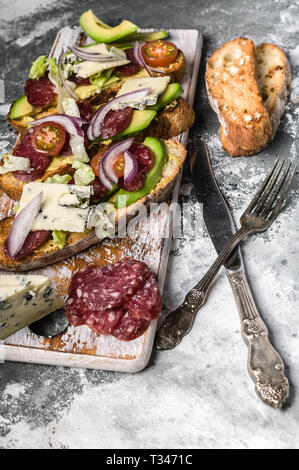 Traditional italian panini sandwiches with smoked sausage, crispy salad and blue cheese. Stock Photo