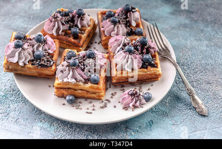 Homemade Belgian waffles with cream, jam, blueberry and mint leaves. Delicious Dessert Stock Photo