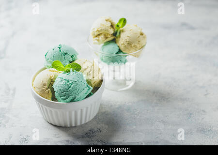 Mint and lemon ice cream with mint leaves in ceramic bowl on light background Stock Photo