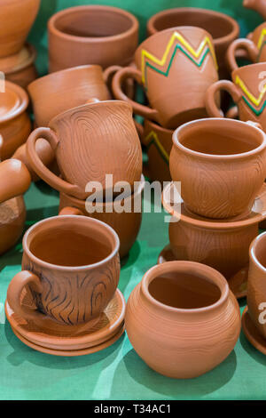 Lots of traditional ukrainian handmade clay pottery production. brown pottery. Clay plates and cups. vertical photo. Stock Photo