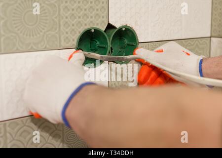 Installing double electrical socket box. Renovation and construction in kitchen Stock Photo