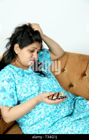 Picture of pregnant woman is irritating in the medicine. Isolated on the white background. Stock Photo
