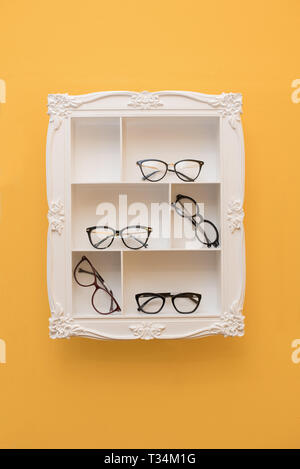 Spectacles on shelves in a frame Stock Photo