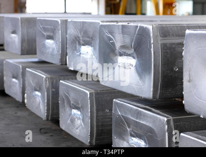 heavy aluminum ingots stacked in a warehouse foundry, raw material to be processed in a hot mill Stock Photo