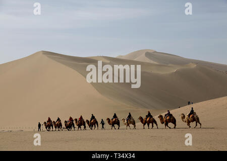 Jiuquan, China's Gansu Province. 6th Apr, 2019. Tourists visit the Mingsha Mountain and Crescent Moon Spring scenic area on the second day of a three-day Qingming Festival national holiday in Dunhuang, northwest China's Gansu Province, April 6, 2019. Credit: Zhang Xiaoliang/Xinhua/Alamy Live News Stock Photo