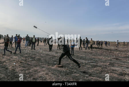 Gaza, khan younis, Palestine. 5th Apr, 2019. A Palestinian demonstrator seen throwing a stone using a slingshot during the clashes.Israeli forces intervened to disperse Palestinians demonstrators causing clashes during a ''Great March of Return'' demonstration on Israeli Border of eastern Khan Yunis, in Gaza. Credit: Yousef Masoud/SOPA Images/ZUMA Wire/Alamy Live News Stock Photo