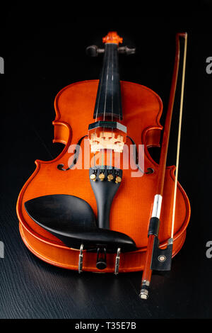 Beautiful new shiny violin on a dark table. Musical string instrument ...