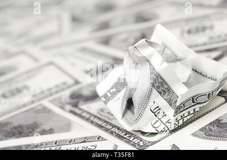Crumpled dollar bill of the United States lies on the set of smooth money bills. Concept of unreasonable waste of money Stock Photo
