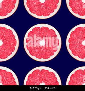 Large pink grapefruit halves on a dark blue background Stock Photo