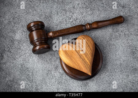 Gavel and wooden heart on concrete gray background. Family law concept Stock Photo